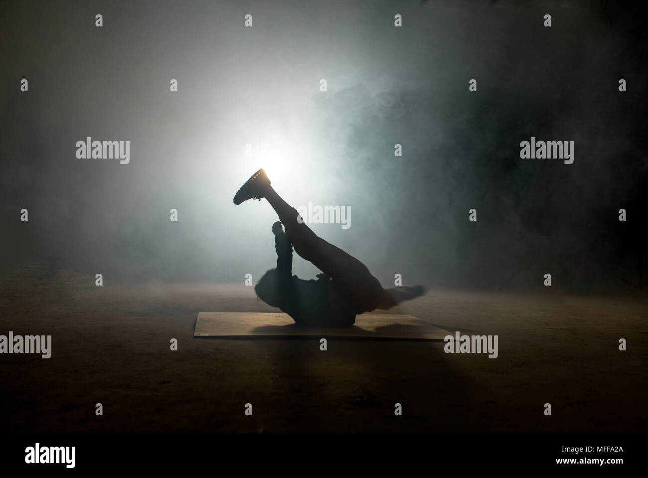 Kerl, Stunts auf der Rückseite. Spinnen auf Matte außerhalb. Schwierige Bewegung. wie Breakdance Stockfoto