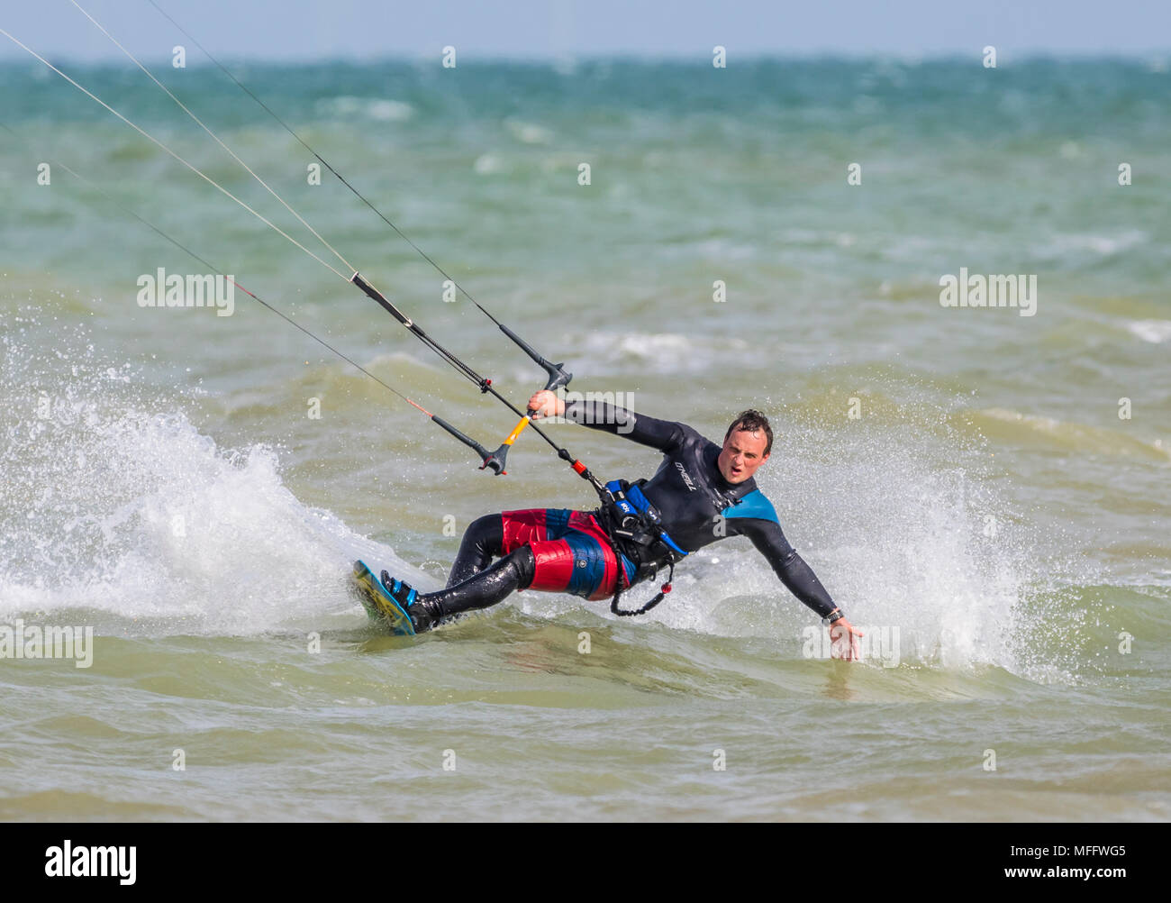 Man Kitesurfen auf See. Wassersport. Kitesurfer schiefen über Holding auf mit einer Hand. Stockfoto