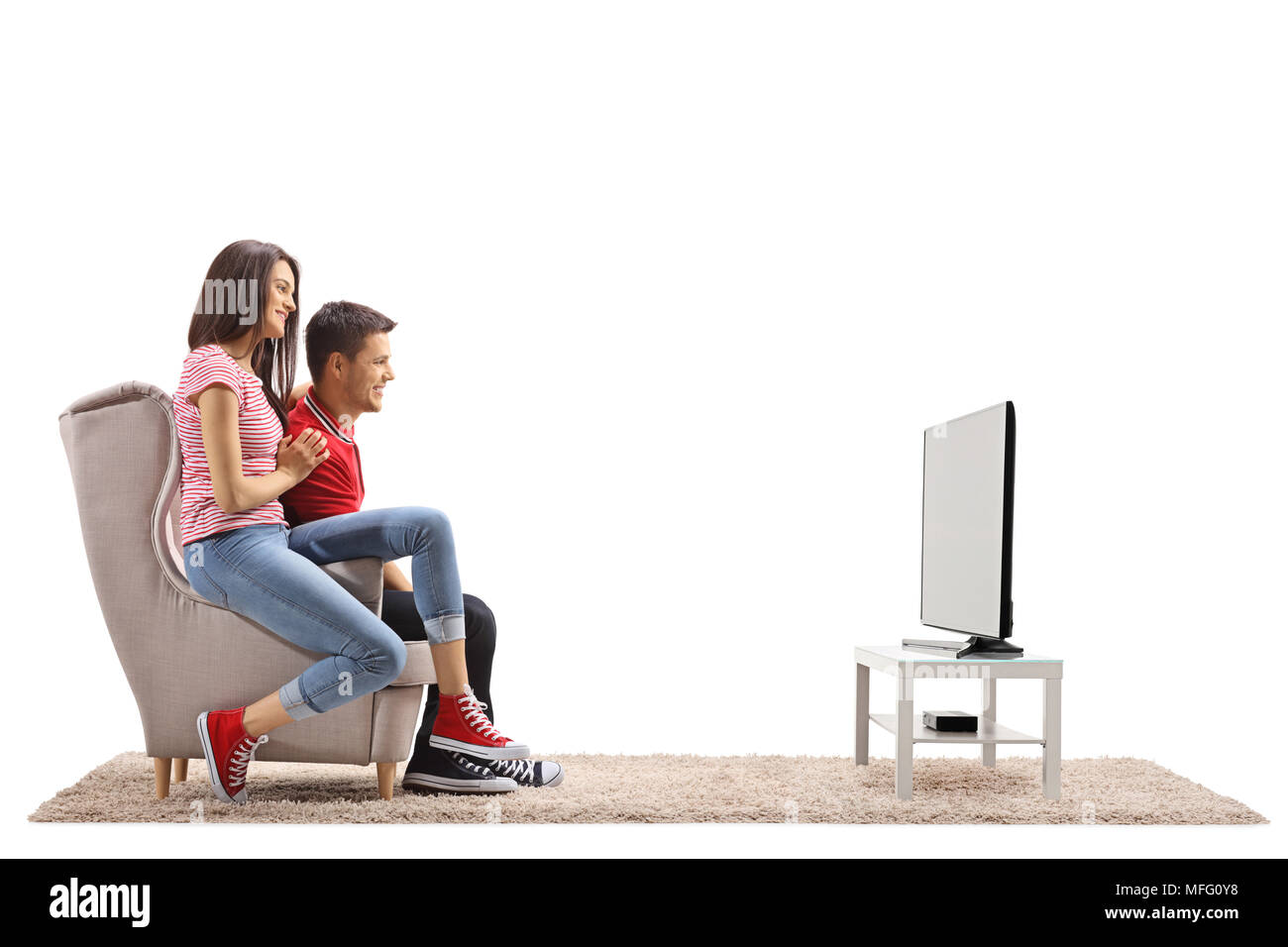 Junges Paar sitzt in einem Sessel und Fernsehen auf weißem Hintergrund Stockfoto