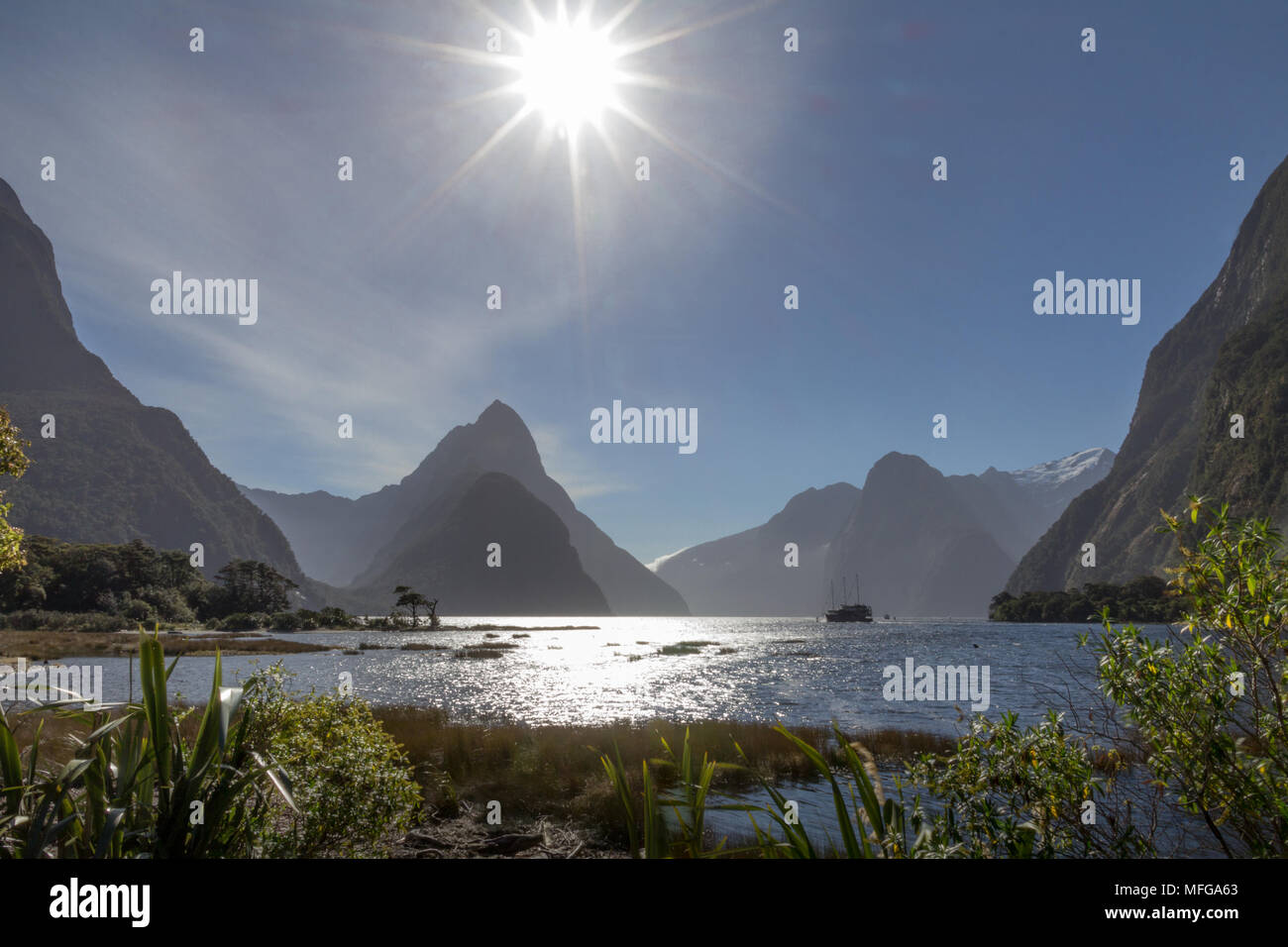 Schönen Star Burst Effekt wie Sun kommt näher zu einem Horizont von iconic Gipfel rund um der Südinsel Milford Sound in Neuseeland. Stockfoto