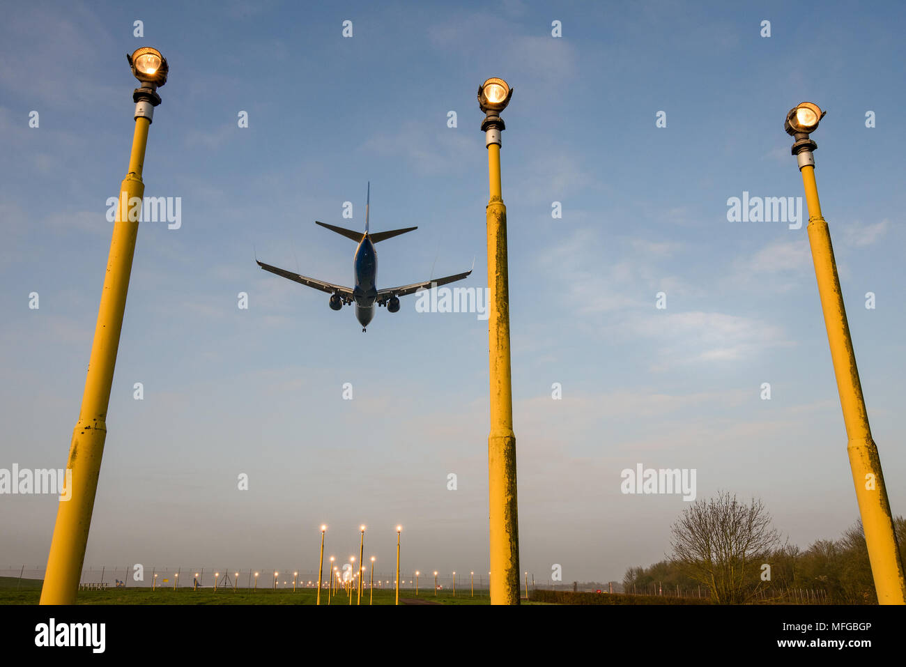 Die Unterseite einer Landung Commercial Airplane mit Fahrwerk unten durch Reihen von Start- und Landebahn landescheinwerfer gesehen. Der internationale Flughafen Stansted, En Stockfoto