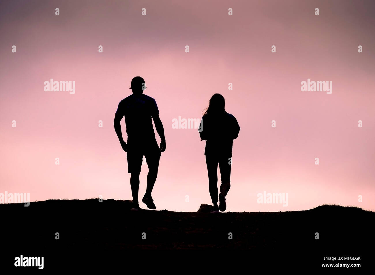 Ein paar Silhouette gegen einen lebendigen rosa Himmel. Stockfoto