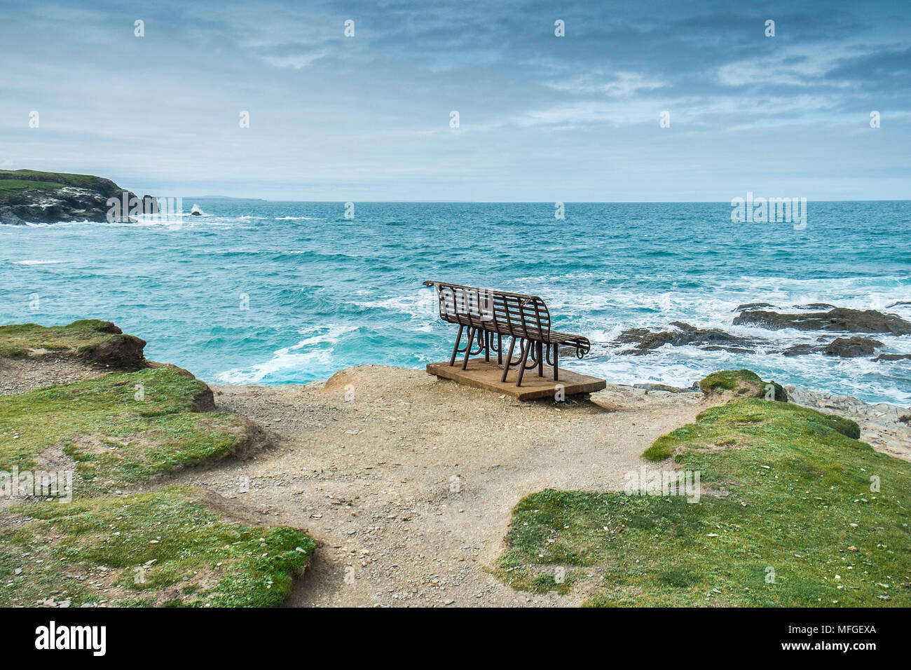 Ein rostiger Schmiedeeisen Sitzbank an der Küste mit Blick auf das Meer bei Treyarnon Bay. Stockfoto