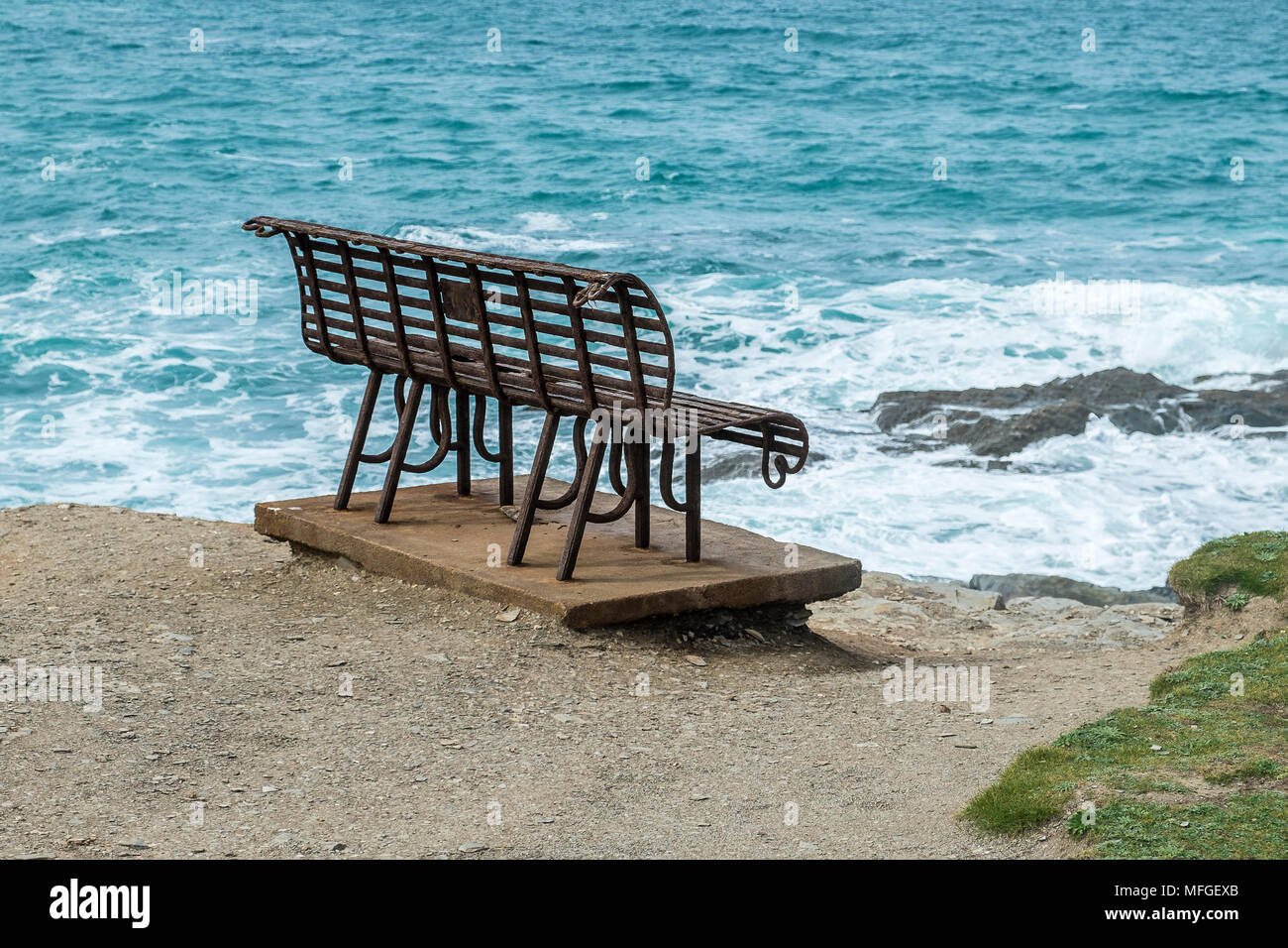 Ein rostiger Schmiedeeisen Sitzbank an der Küste mit Blick auf das Meer. Stockfoto