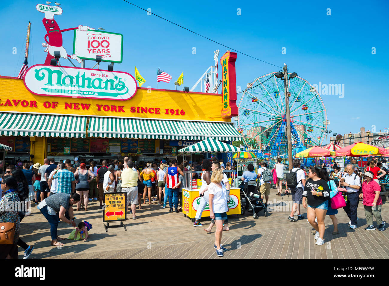 NEW YORK CITY - 20. AUGUST 2017: Besucher gehen die ikonischen Holz- Coney Island boardwalk außerhalb Hot Dog stand die berühmte Nathan an einem heißen Sommertag Stockfoto