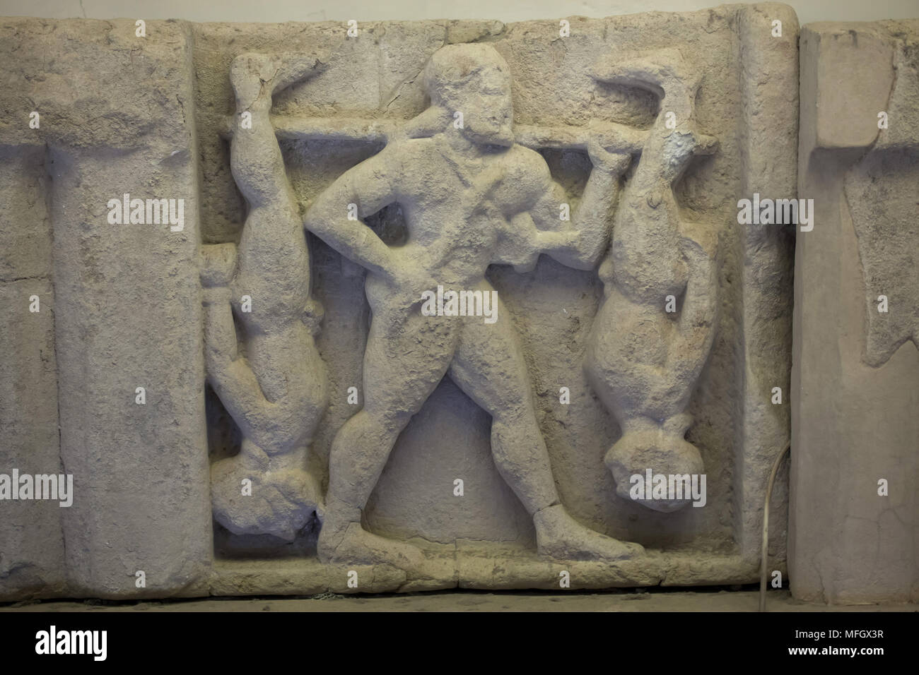 Herakles Bestrafung der Cercopes. Archaische Sandstein metope aus dem Heraion (Erste Tempel der Hera) in Foce del Sele aus der Mitte des 6. Jahrhunderts v. Chr. datiert auf Anzeige im Paestum Archäologischen Museum (Museo Archeologico di Paestum) in Paestum, Kampanien, Italien. Stockfoto