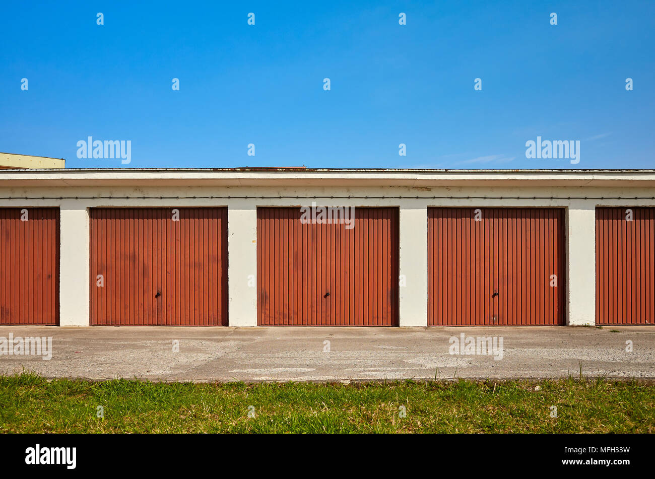 Reihe von Garagen mit geschlossenen Türen an einem sonnigen Tag. Stockfoto