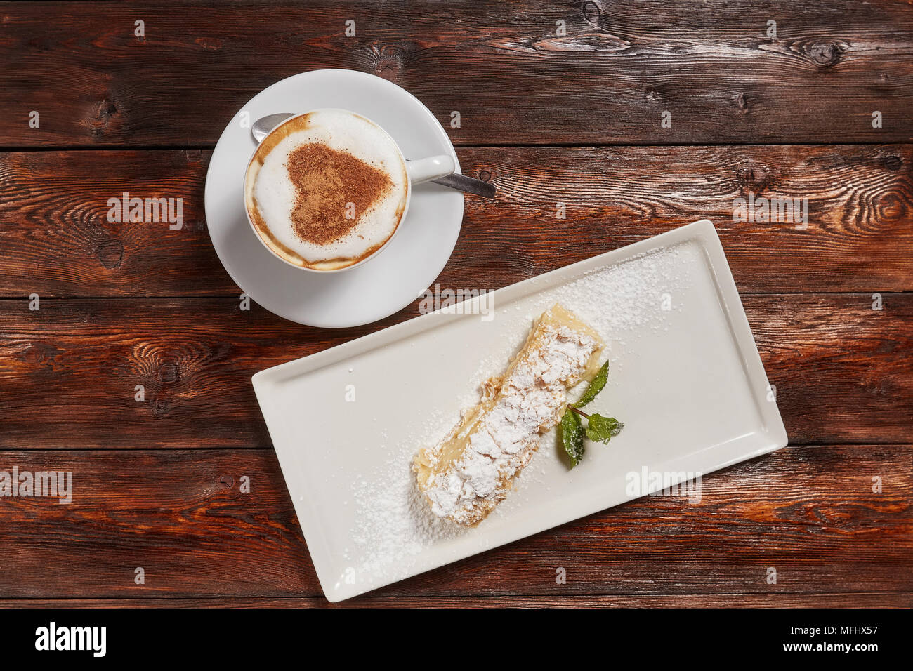 Ansicht von oben Latte Art Kaffee mit Herz und Kuchen auf Platte, Holz- Hintergrund Stockfoto