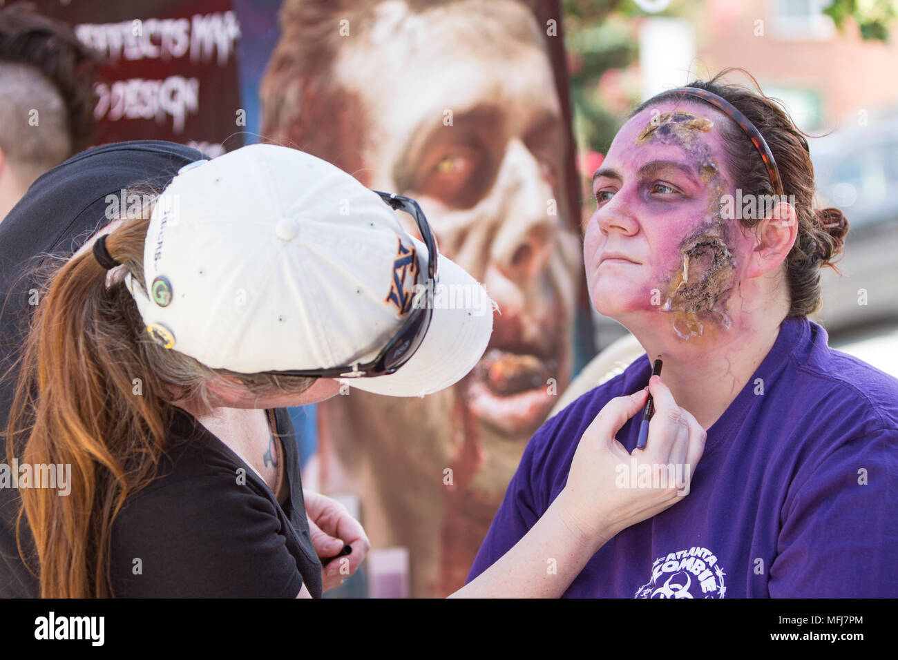 Eine Make-up-Künstler schafft realistische fleischigen Wunden in das Gesicht einer Frau vor der Atlanta Zombie Pub Crawl am 25 Juli, 2015 in Atlanta, GA. Stockfoto