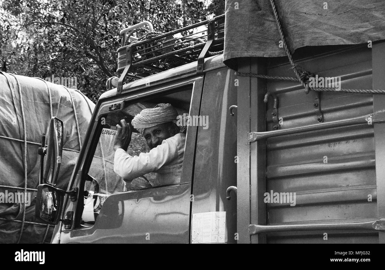 Indischen LKW-Fahrer, die eine freundliche Welle von einem vorbeifahrenden Zug Transporter, Indien Stockfoto