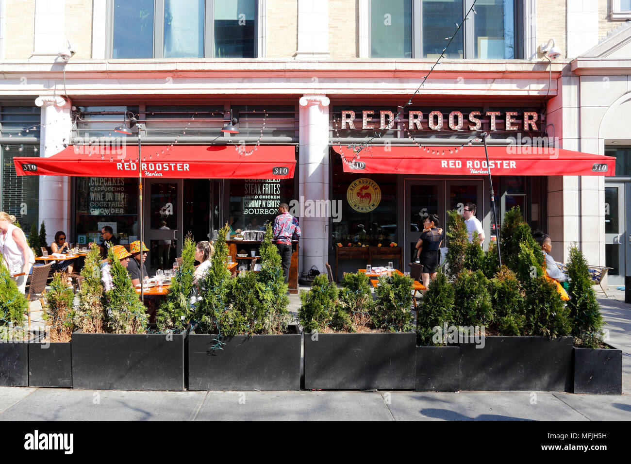 Red Rooster, 310 Malcolm X Blvd, New York, NY. aussen Storefront einer Soul Food Restaurant und Straßencafé in Harlem, in Manhattan. Stockfoto