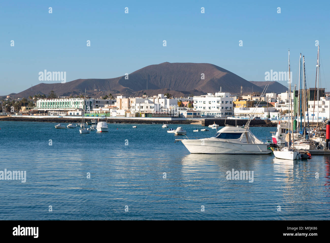 Der Hafen von Corralejo auf Fuerteventura mit einem Vulkan in der Ferne, Fuerteventura, Kanarische Inseln, Spanien, Atlantik, Europa Stockfoto