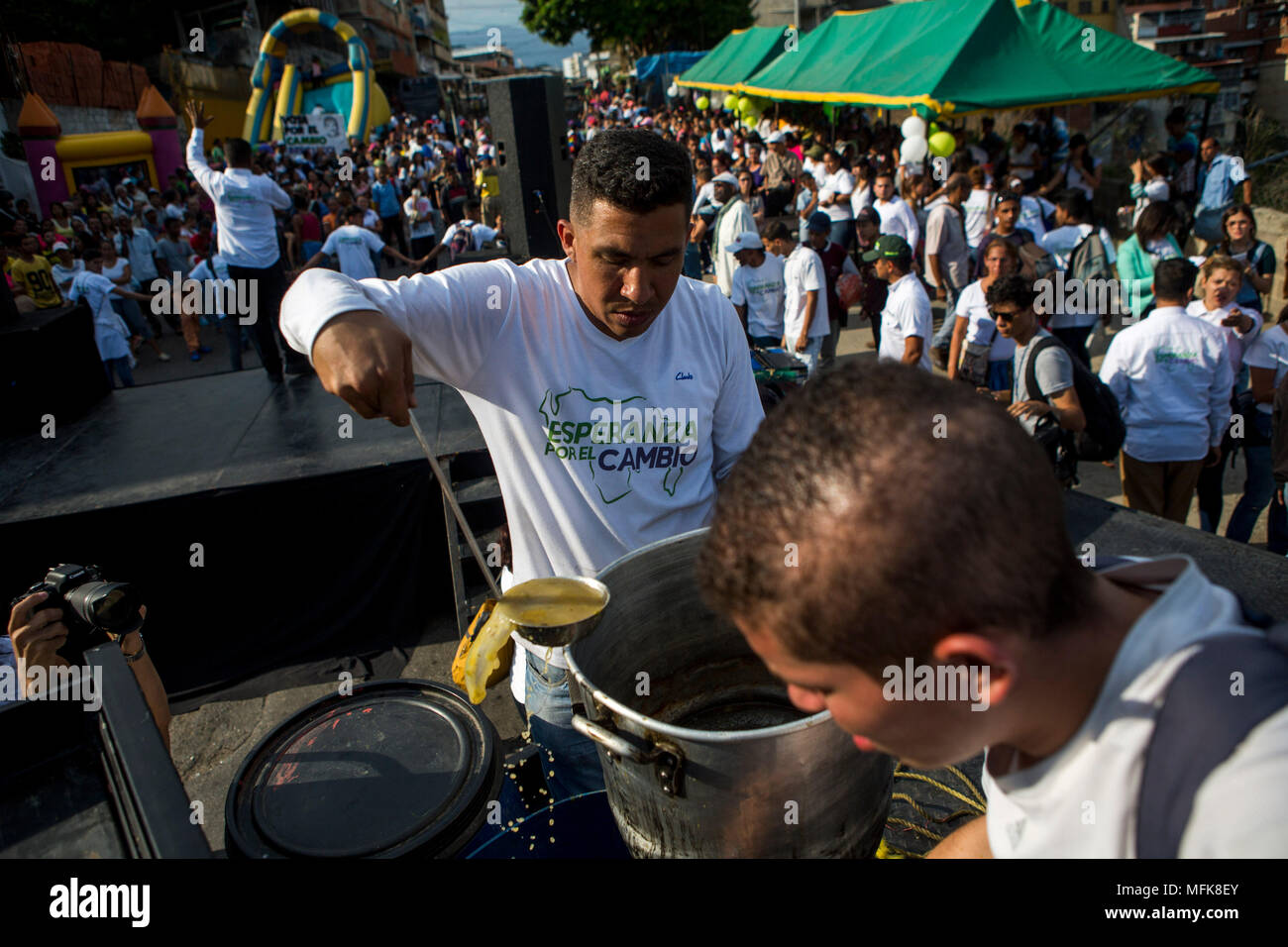 25. April 2018, Venezuela, Caracas: ein Mann in einem T-Shirt der Partei 'Esperanza para un Cambio" (Hoffnung auf Veränderung) verteilt Essen in einer Abstimmung von Kandidat Bertucci. Der evangelische Pastor wird auf der kommenden Wahl am 20. Mai gegen den derzeitigen Staatschef Maduro erscheinen. Gleichwohl waren viele Staaten und internationale Organisationen befürchten, dass die Wahlen nicht frei und fair sein. Foto: Manaure Quintero/dpa Stockfoto