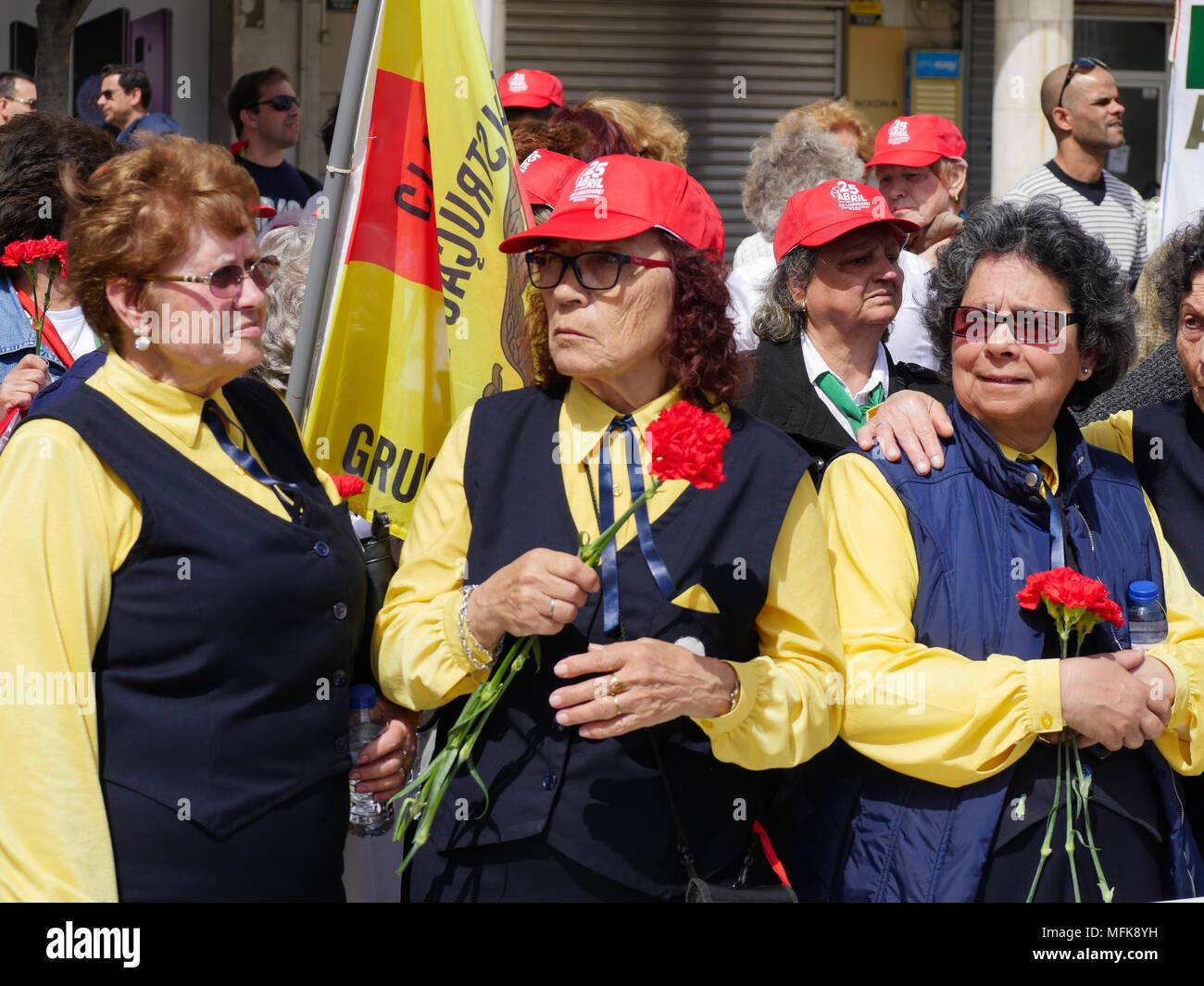 Lissabon, Portugal, 25. April 2018: Die Menschen in den Straßen von der beliebte Stadtteil Almada gesehen, in Lissabon (Portugal), wie sie sich an den Feierlichkeiten zum 44. Jahrestag des Nelken Revolution nehmen. Bei dieser Gelegenheit, jungen und alten Menschen, Mitglieder der retrired, Sport ou Musik Verbände, Verunreinigen auf der Straße, das Tragen der roten Kappen und mit roten Nelken Hommage an die Revolution 1974 die Gedrivet der alten Rechten diktatorischen Regimes von António de Oliveira Salazar zu bezahlen. Credit: Serge Mouraret/Alamy leben Nachrichten Stockfoto