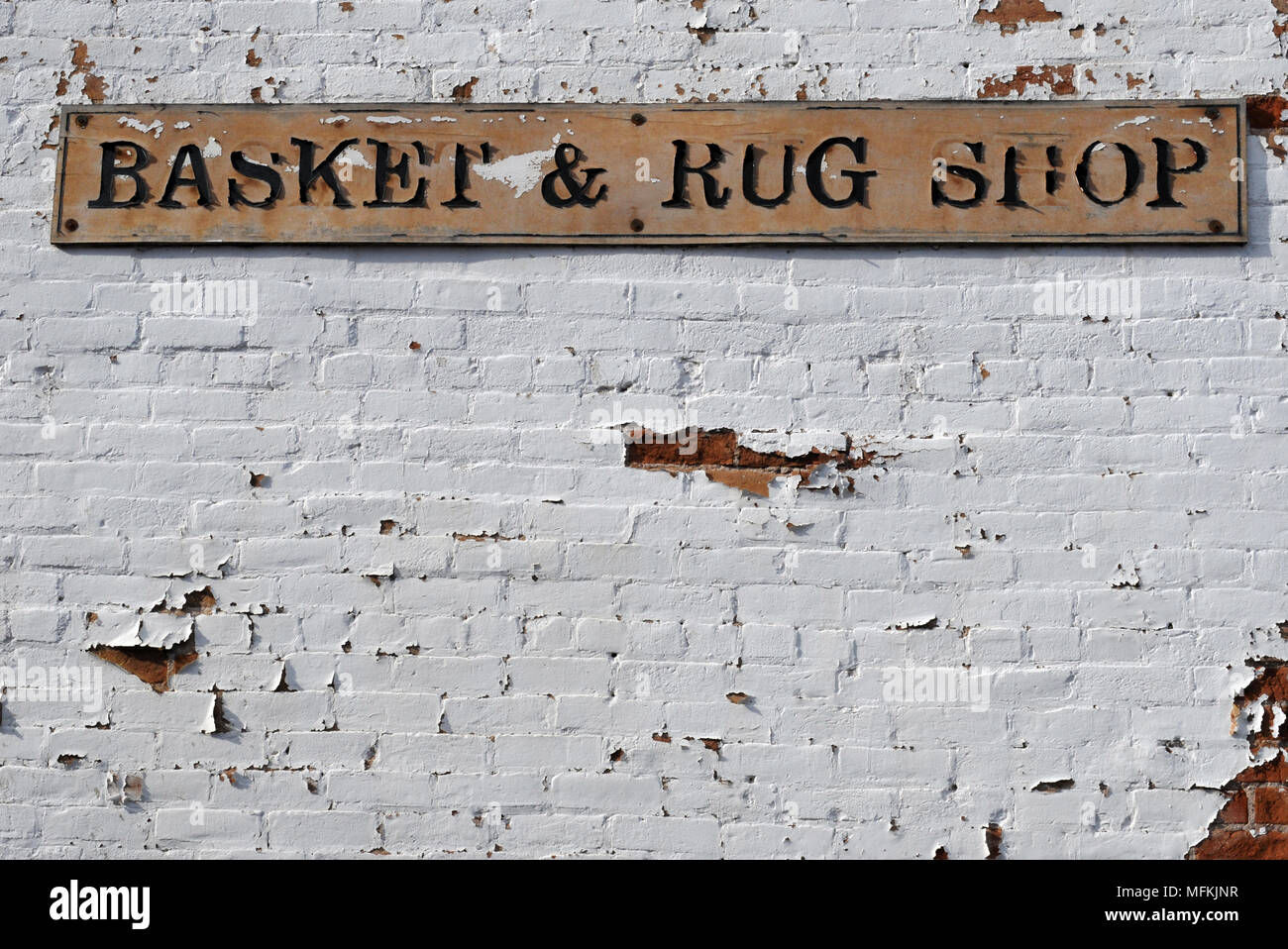 Ein Zeichen für einen Korb und Teppich Shop auf einem weiß getünchten Mauer in der Altstadt von Albuquerque, New Mexico hängt. Stockfoto