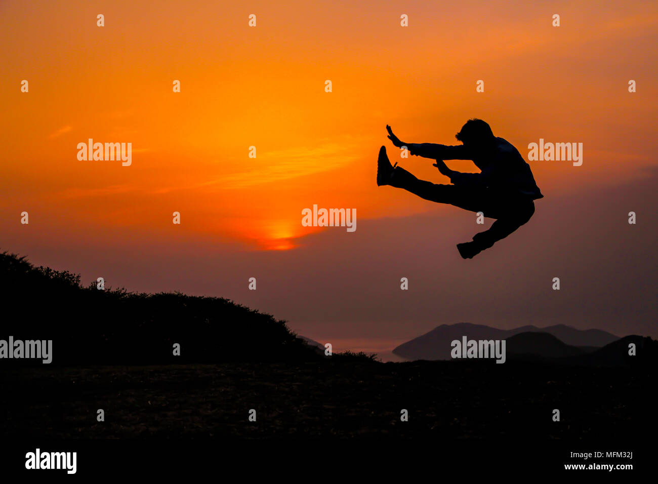 Silhouette der junge Mann springen mit der Dämmerung Himmel. Stockfoto