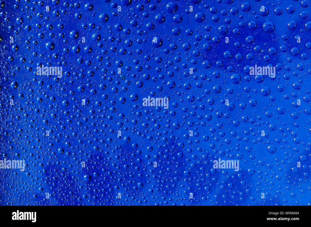 Wassertropfen auf einer Glasoberfläche blau Stockfoto