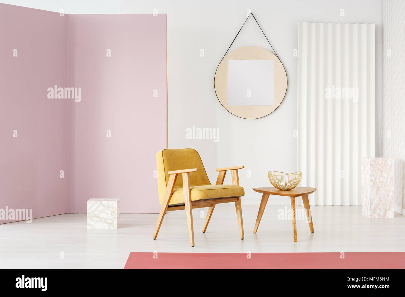 Großer runder Spiegel mit Rahmen aus Holz hängend auf einer weißen Wand  eines minimalistischen Wohnzimmer mit stilvollen Möbeln und Marmor Cubes  Stockfotografie - Alamy