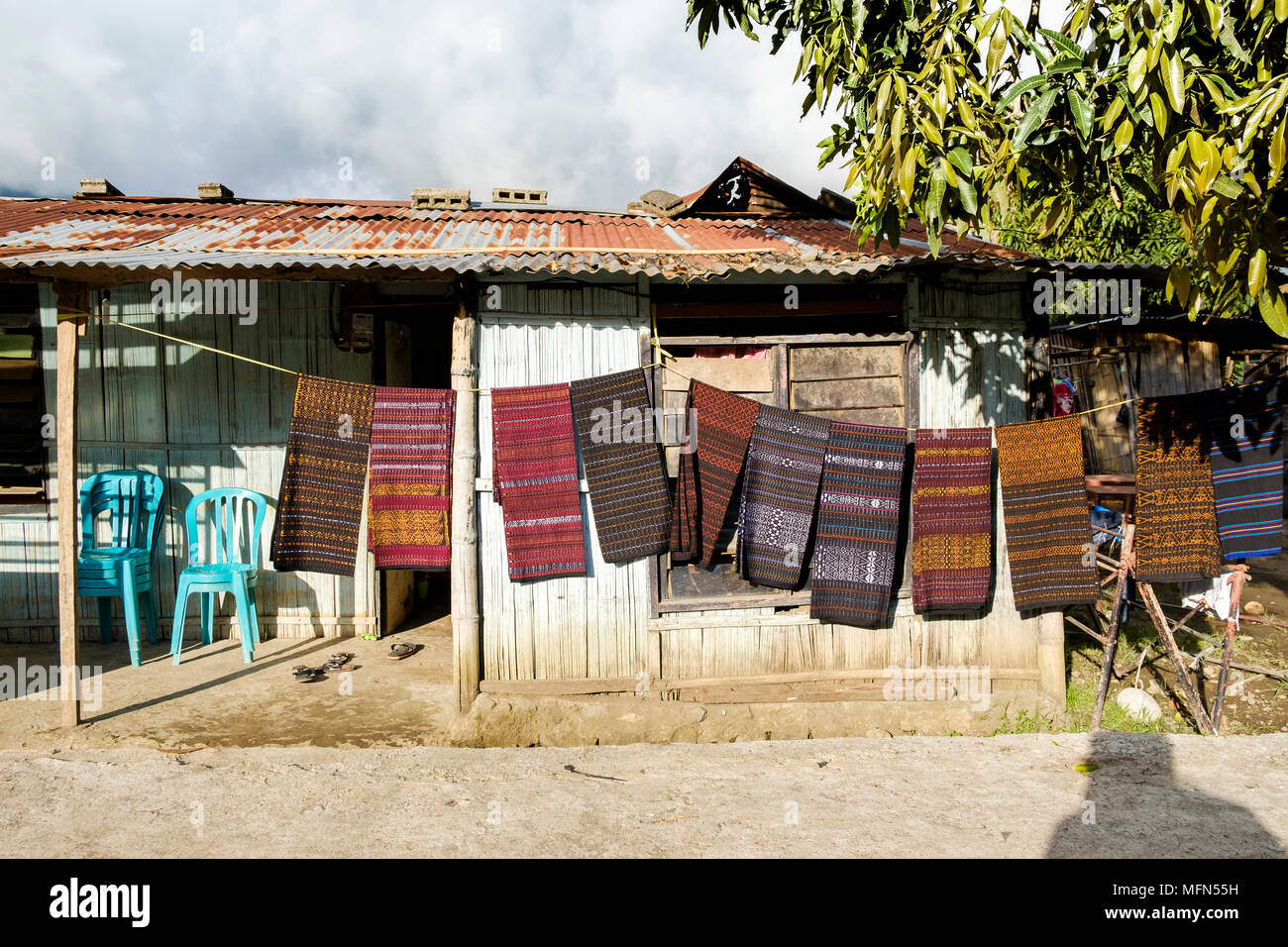 Stücke von Ikat (ein traditioneller Webtechnik weit in Indonesien gefunden) hängend an einem Seil vor einem Haus in Moni, Insel Flores (Ost Nusa Zehn Stockfoto