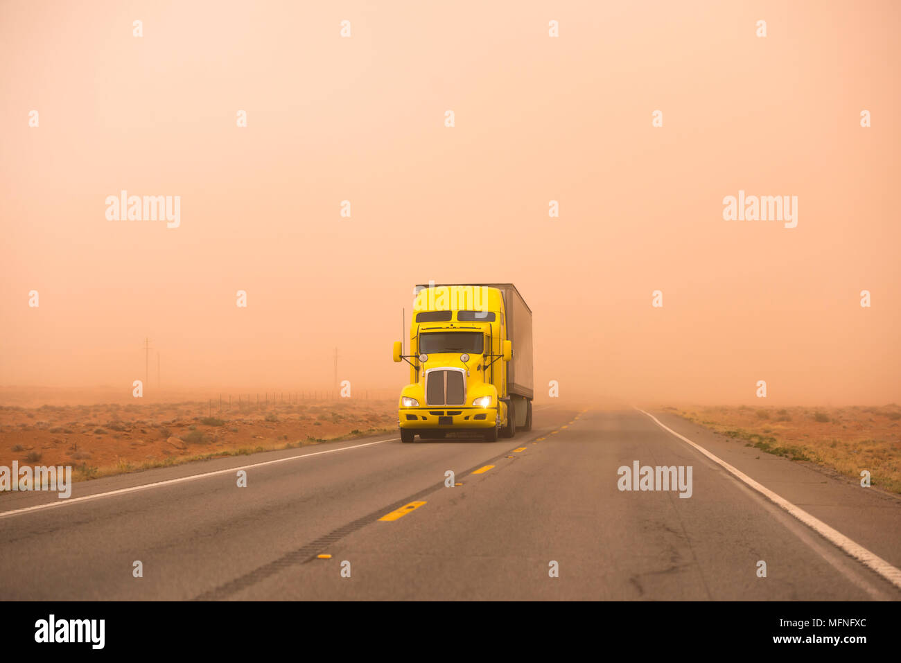 Gelb Big Rig Motorhaube leistungsfähige Semi Truck mit Auflieger Pflege gekühlt reefer Cargo gehen Fahrten während riesige starken Sandsturm mit schlechter Sicht o Stockfoto