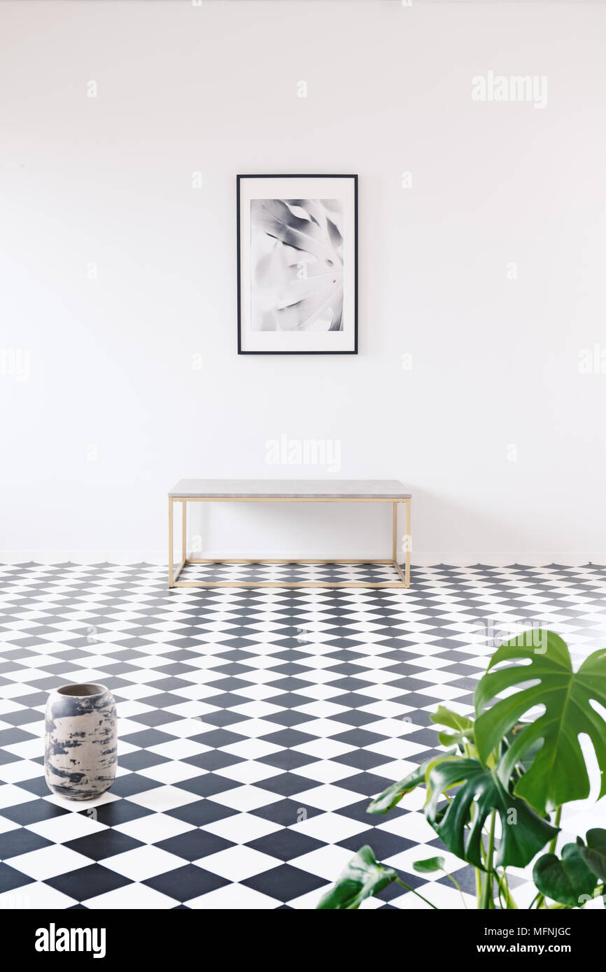 Geräumige Fotografie Galerie in einem minimalistischen schwarze und weiße Wohnung Interieur mit einem goldenen Rahmen, Sitzbank und eine weiße, leere Wand Stockfoto