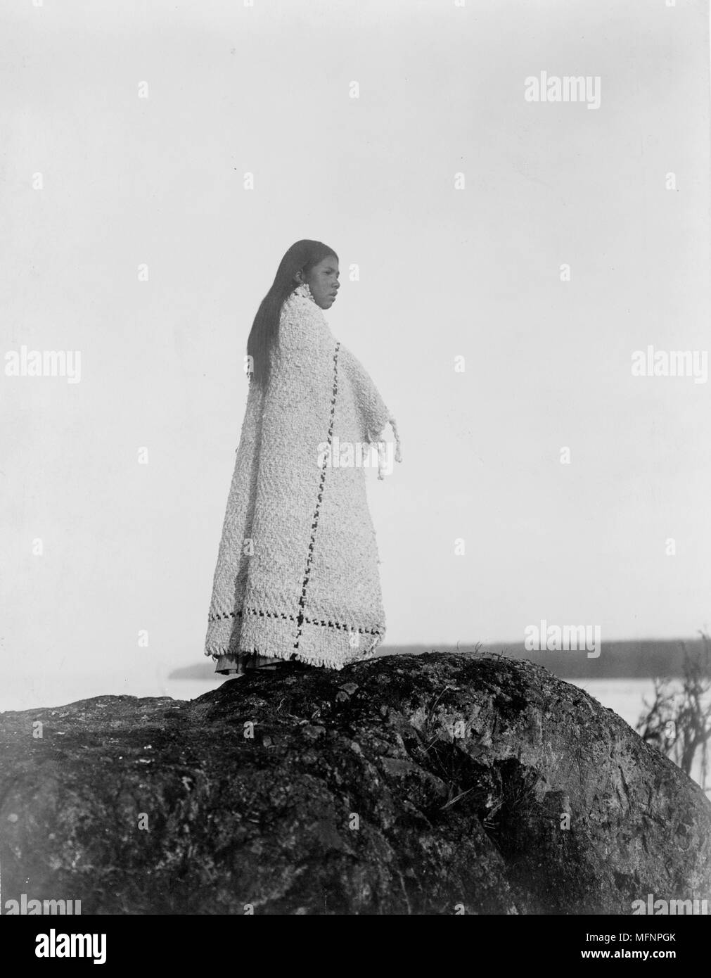 Cowichan Frau, in voller Länge Porträt, das Tragen von Decke, stehend auf Rock, c 1913. Foto von Edward Curtis (1868-1952). Stockfoto