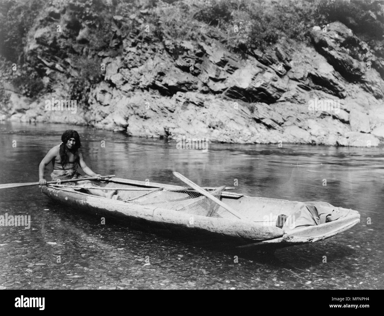 Native American Yurok indische Fischer eine Kanu am Trinity River paddeln. Stockfoto