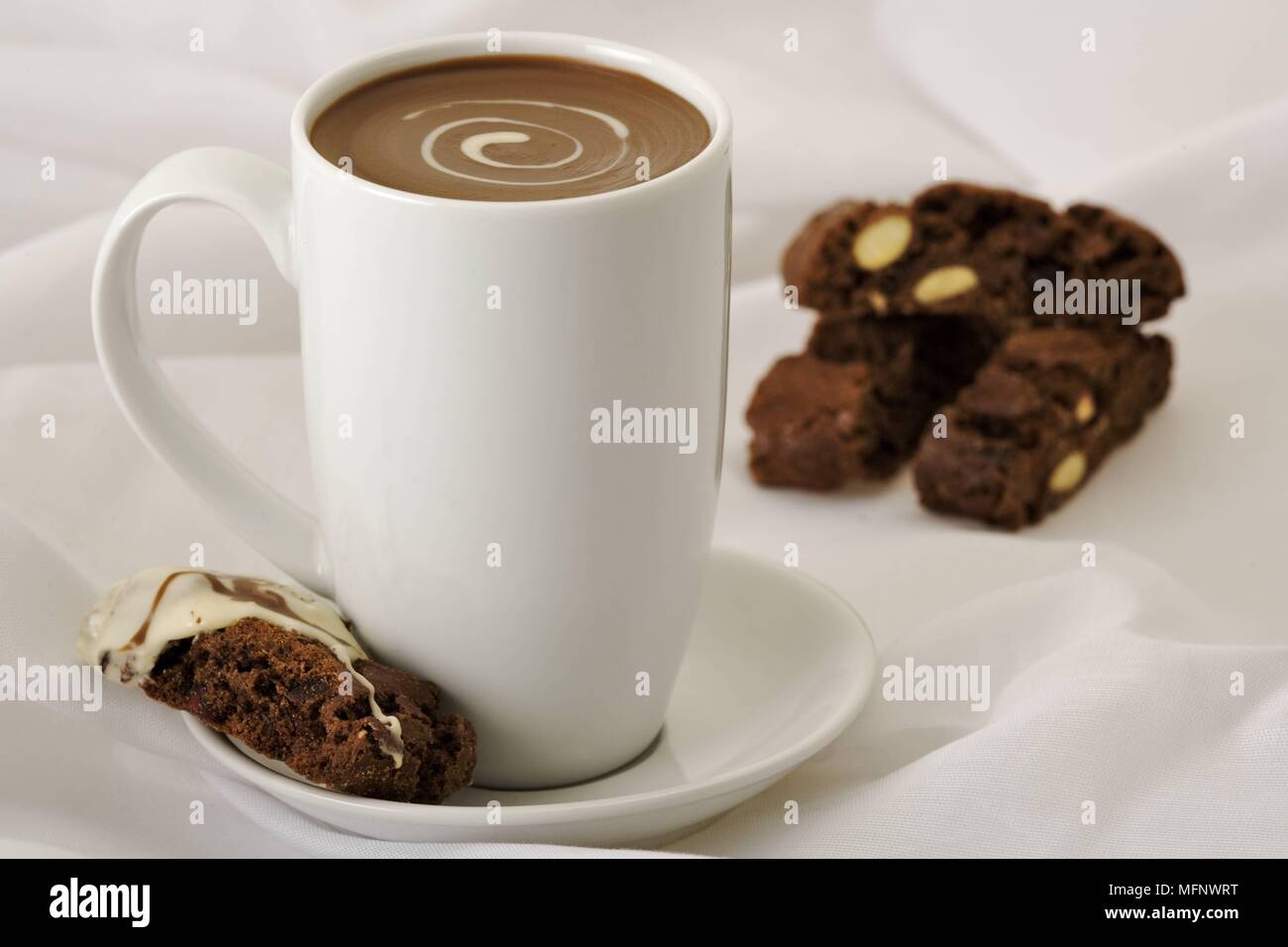 Weißes Porzellan Tasse mit Trinkschokolade. Mandeln und Schokolade biscoti im Hintergrund. Studio gedreht. Ref: CRB538_103609_0020 obligatorischen CREDI Stockfoto