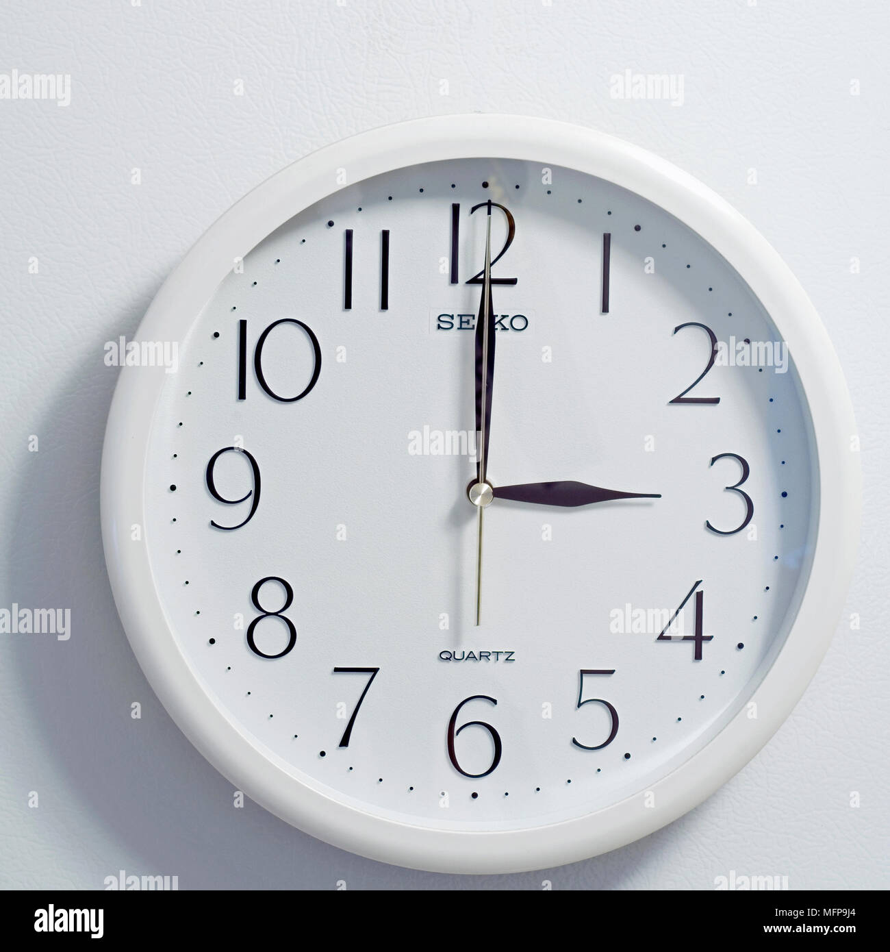 Nahaufnahme des Gesichts des modernen clock Stil, runde weiße und schwarze Zifferblatt zu der Zeit drei Uhr auf weißem Hintergrund Stockfoto