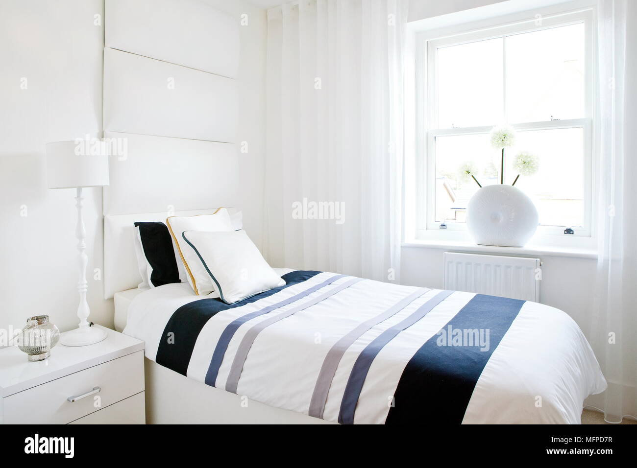 Doppelbett in modernes Schlafzimmer mit blau gestreiften Bettdecken Stockfoto