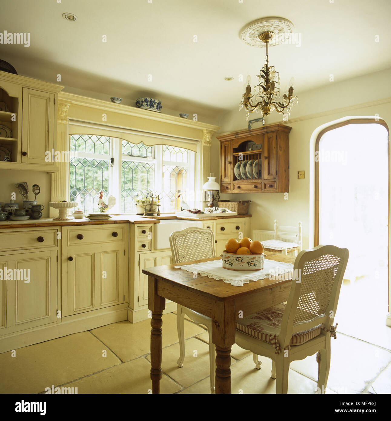 Eine traditionelle Küche mit einer Steinplatte Stock und einen kleinen Esstisch vor der creme Küche Einheiten. Stockfoto