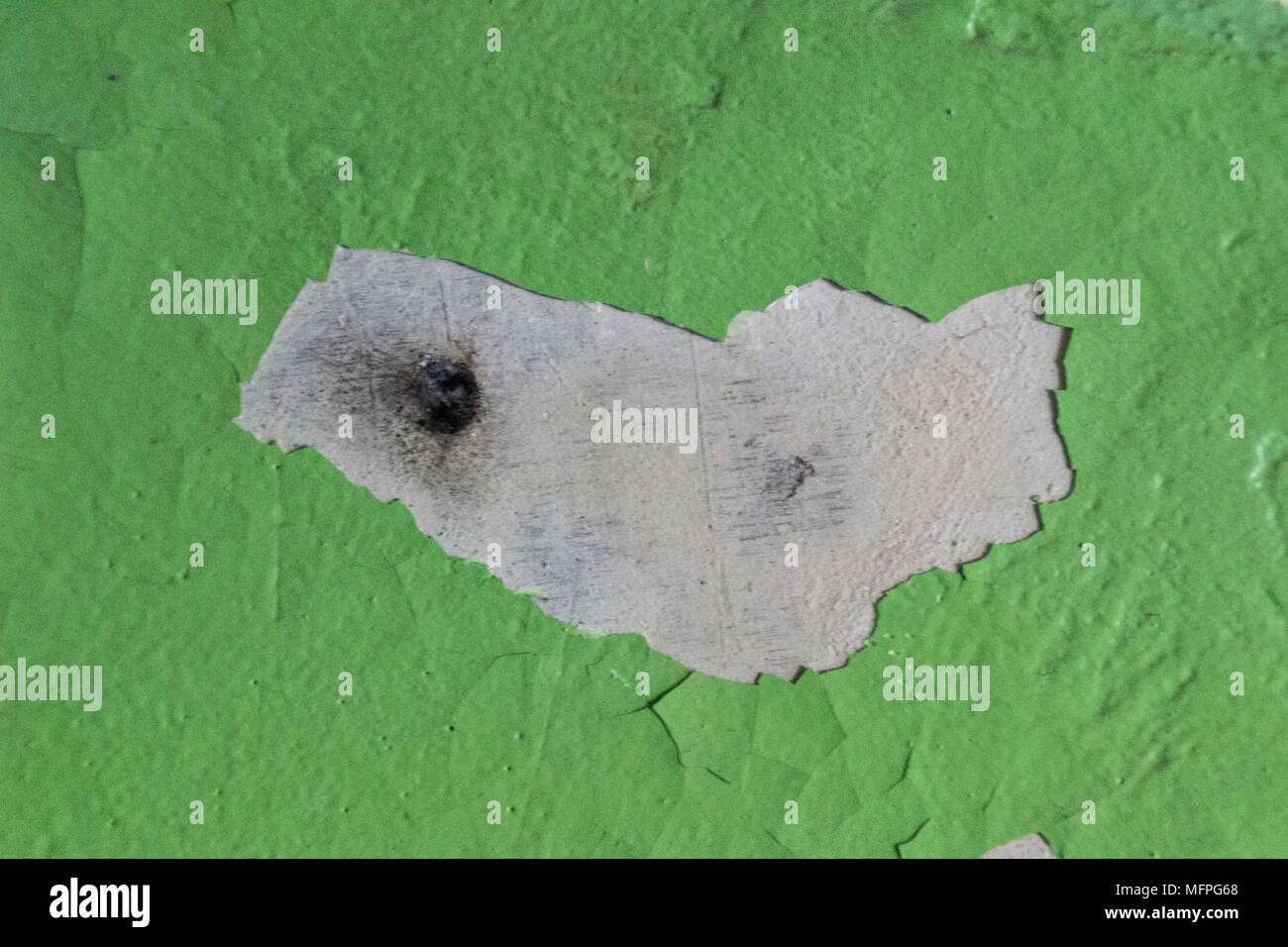 Ein bullet Loch in einer bemalten Wand Stockfoto