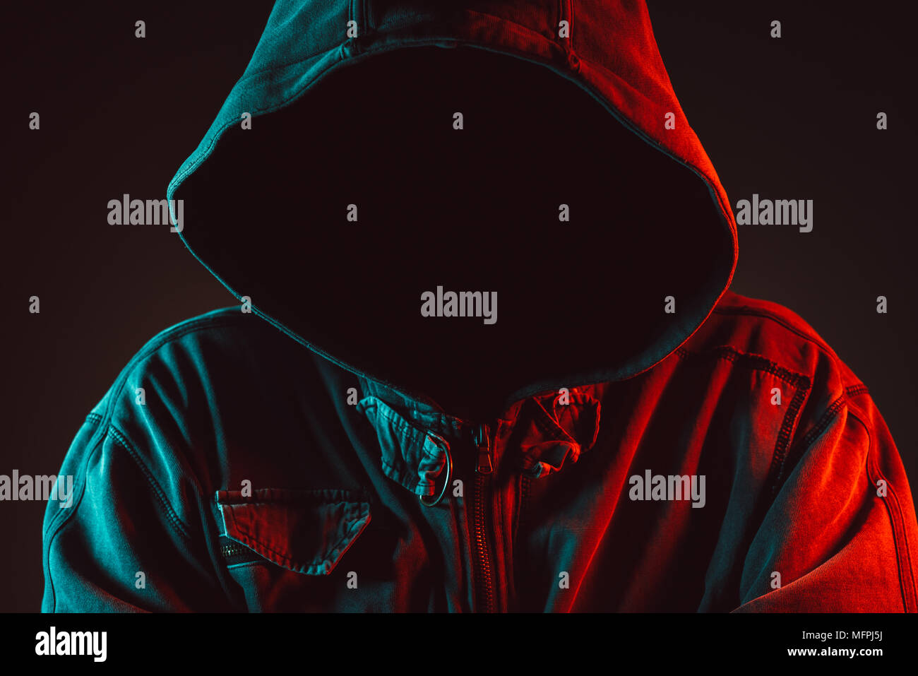 Rot und Blau beleuchtete Low Key Portrait von gesichtslosen Hooded männliche Person für Kriminalität und Gewalt Konzept Stockfoto