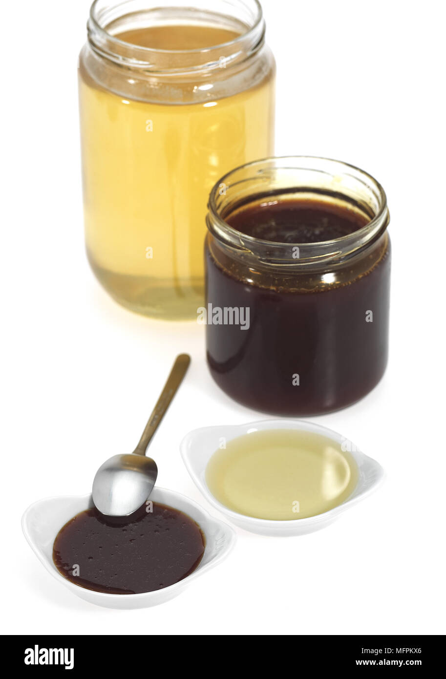 Honig und Sirup Gläser vor weißem Hintergrund Stockfoto