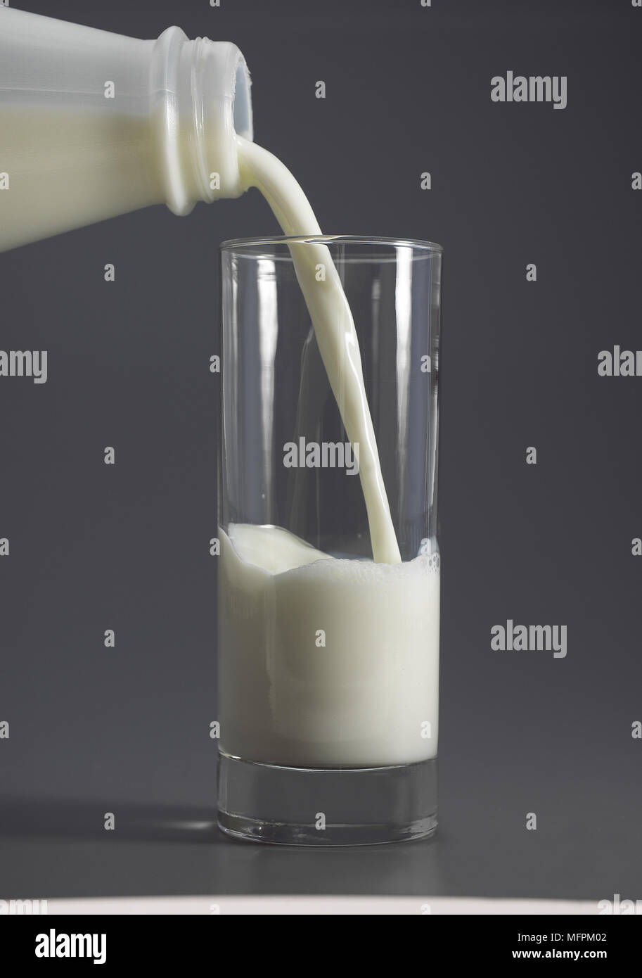 Glas und Flasche Milch gegen grauer Hintergrund Stockfoto