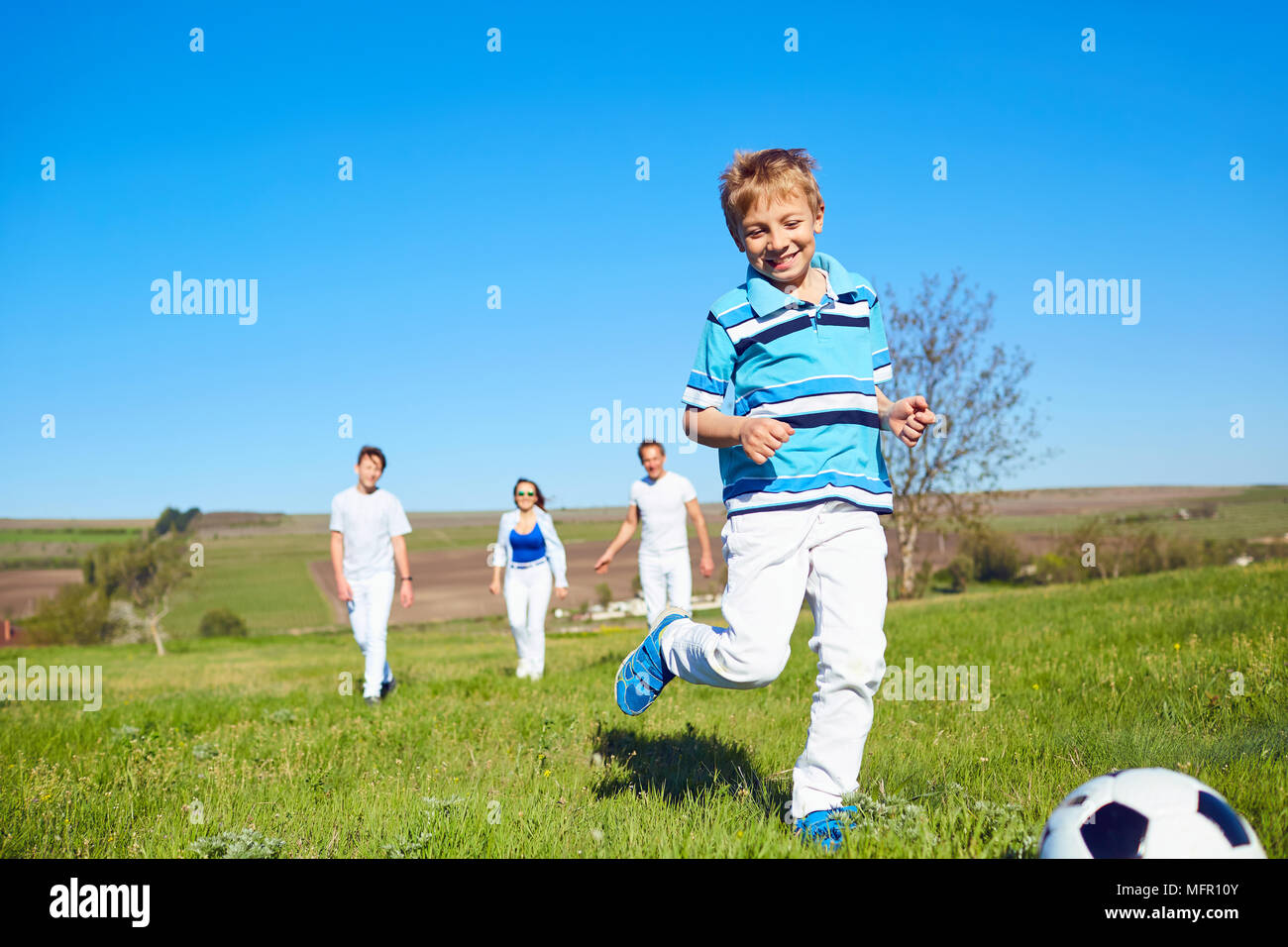 Happy Family spielen mit einem Ball auf die Natur im Frühling, Sommer. Stockfoto