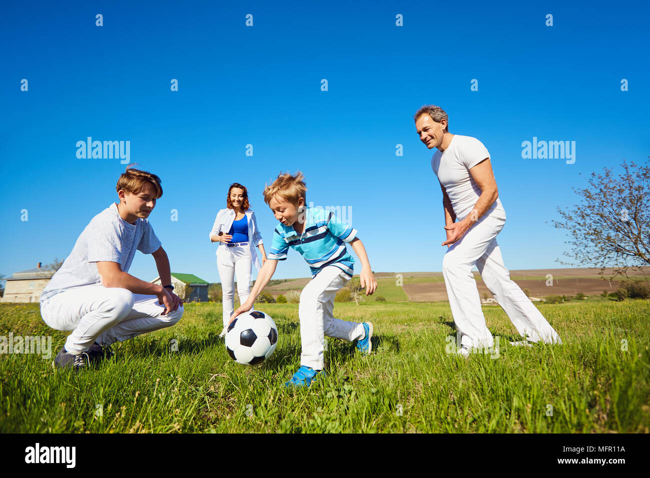 Happy Family spielen mit einem Ball auf die Natur im Frühling, Sommer. Stockfoto
