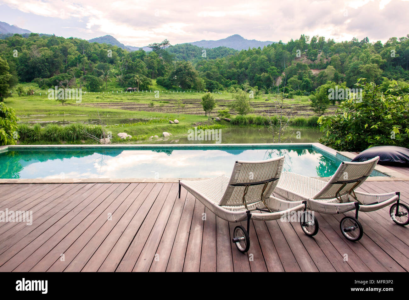 Resort Swimmingpool und Liegestühlen mit Blick auf die Berge Stockfoto