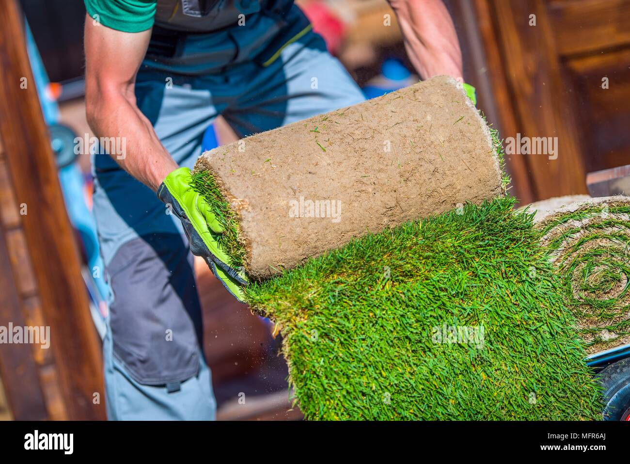 Gras Rasen Garten arbeiten. Kaukasische Gärtner vorbereiten Gras für