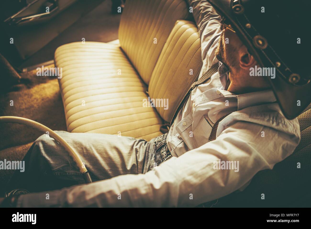 Der Cowboy und seine Fahrt. Kaukasischen Männern in seinem 30s Western tragen in der klassischen amerikanischen Cabriolet. Stockfoto