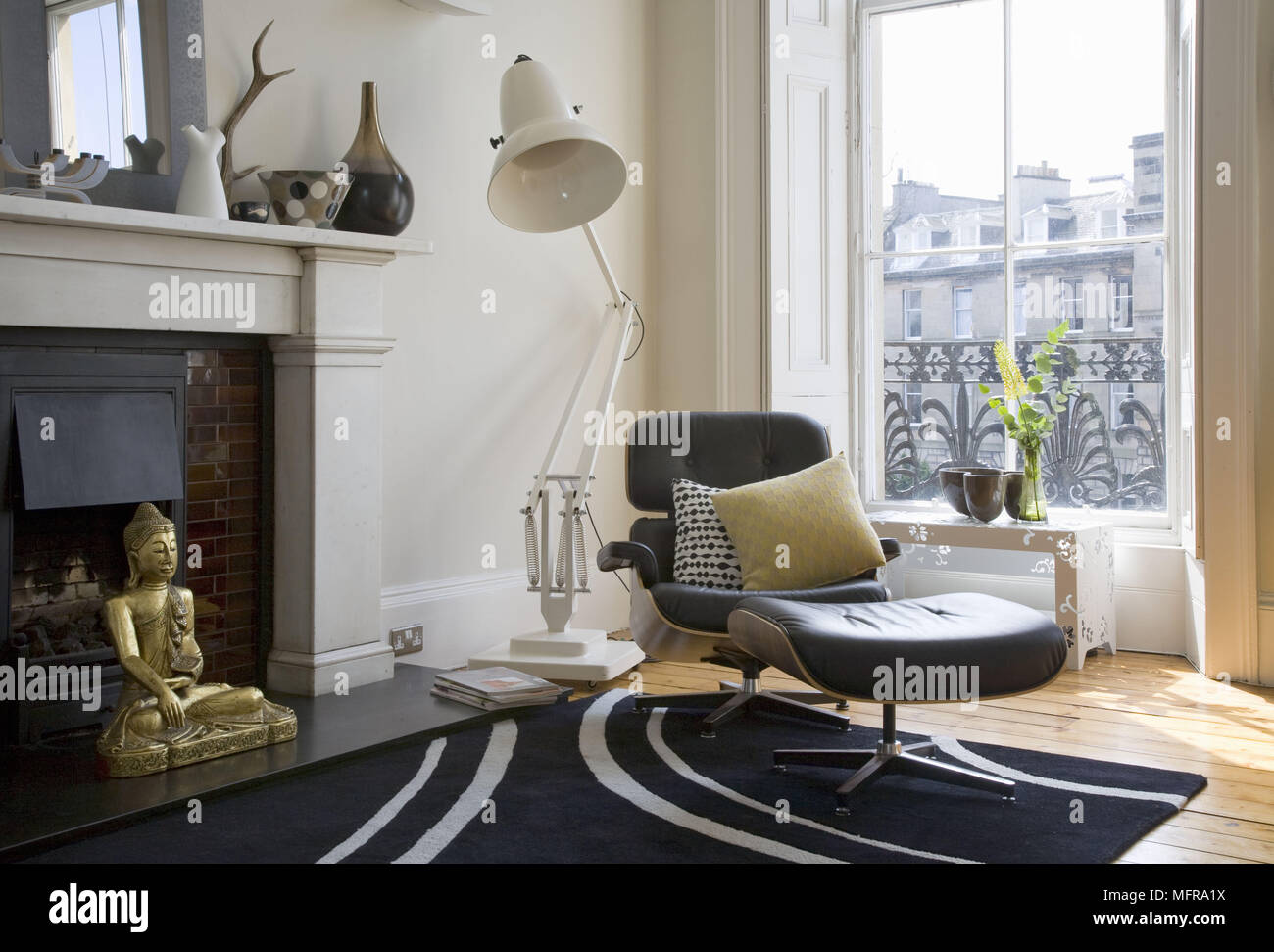 Übergroße anglepoise Stehleuchte hinter Eames Lounge Chair vor Fenster Stockfoto