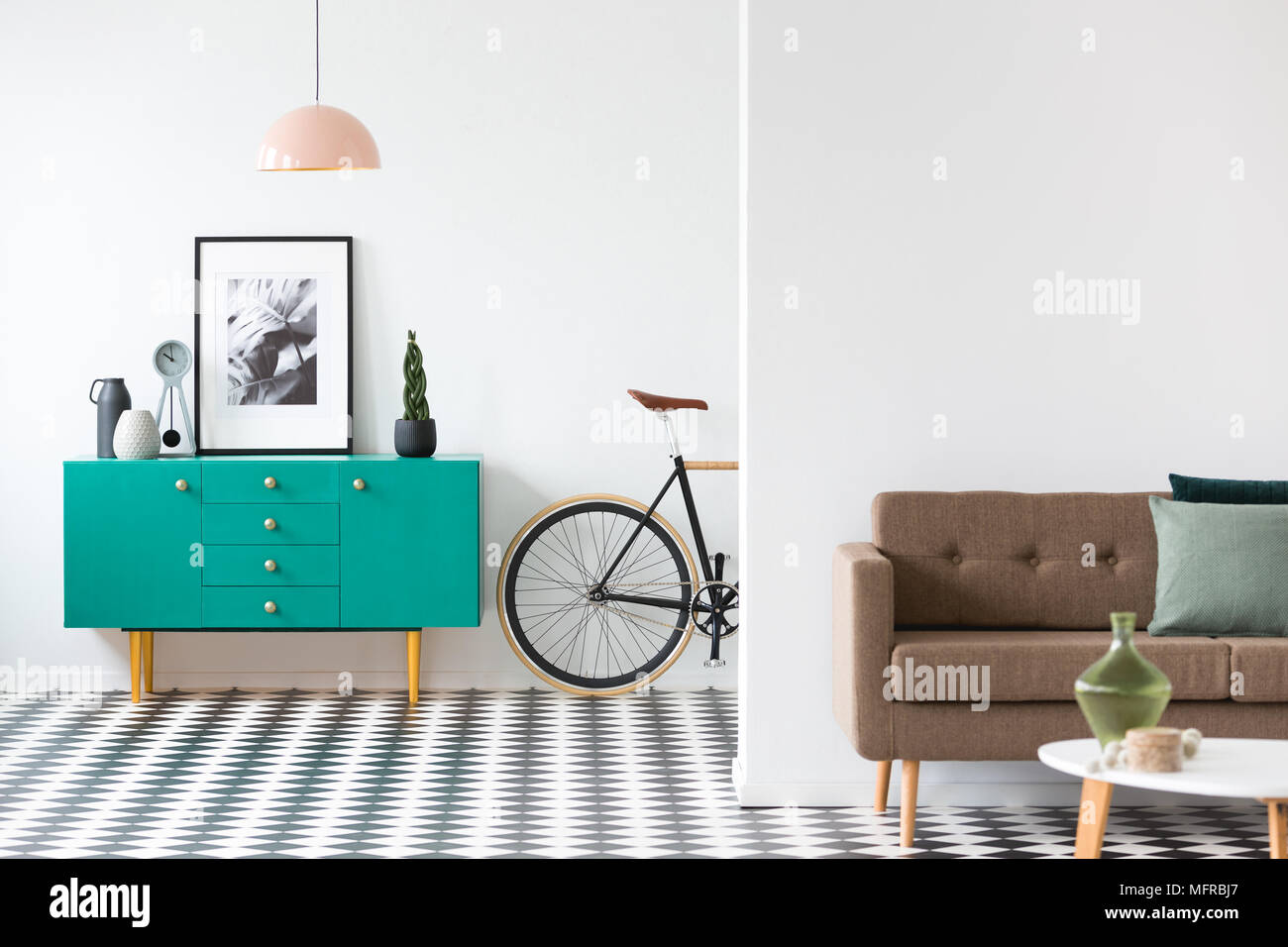 Rosa Lampe über Türkis Schrank mit Plakat in retro Wohnzimmer Einrichtung mit Sofa und Bike Stockfoto