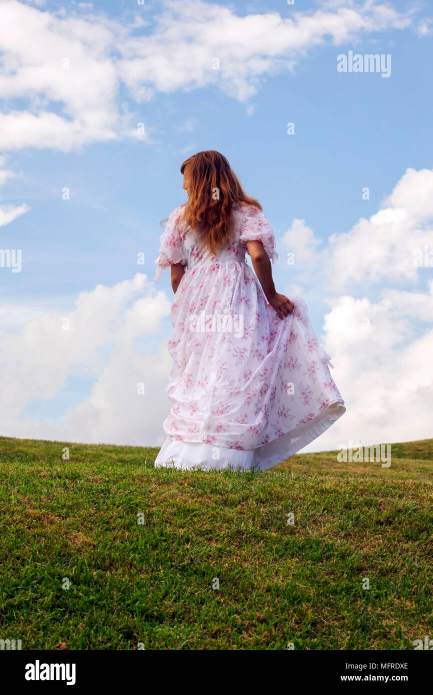 Eine Frau In Einem Kleid Von Flora Lauft Auf Einer Wiese Stockfotografie Alamy