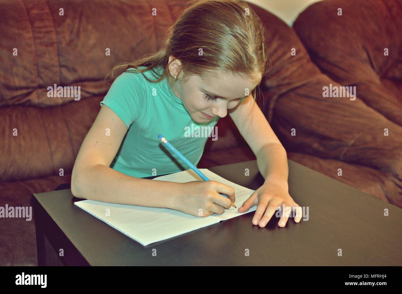 Kleines Mädchen 8 Jahre alt, Schreiben im Notebook Stockfoto