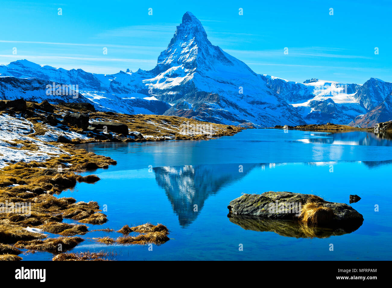 Snowy Matterhorn im teilweise gefrorenen Stellisee, Zermatt, Wallis, Schweiz wider Stockfoto