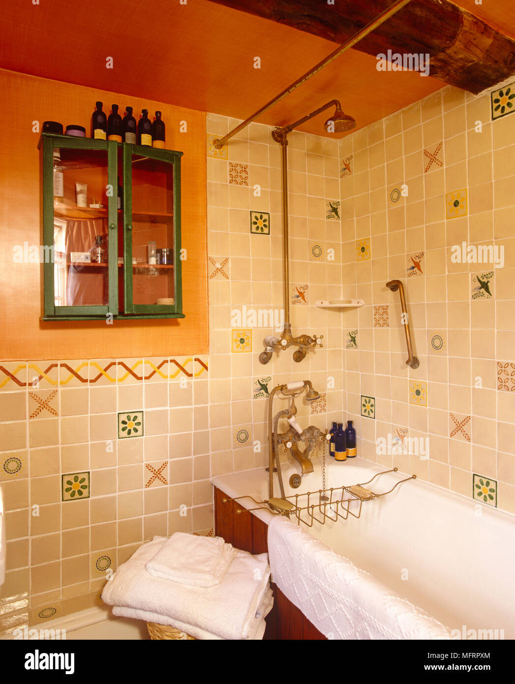 Dusche über Badewanne in Gelb gefliesten Badezimmer Stockfoto