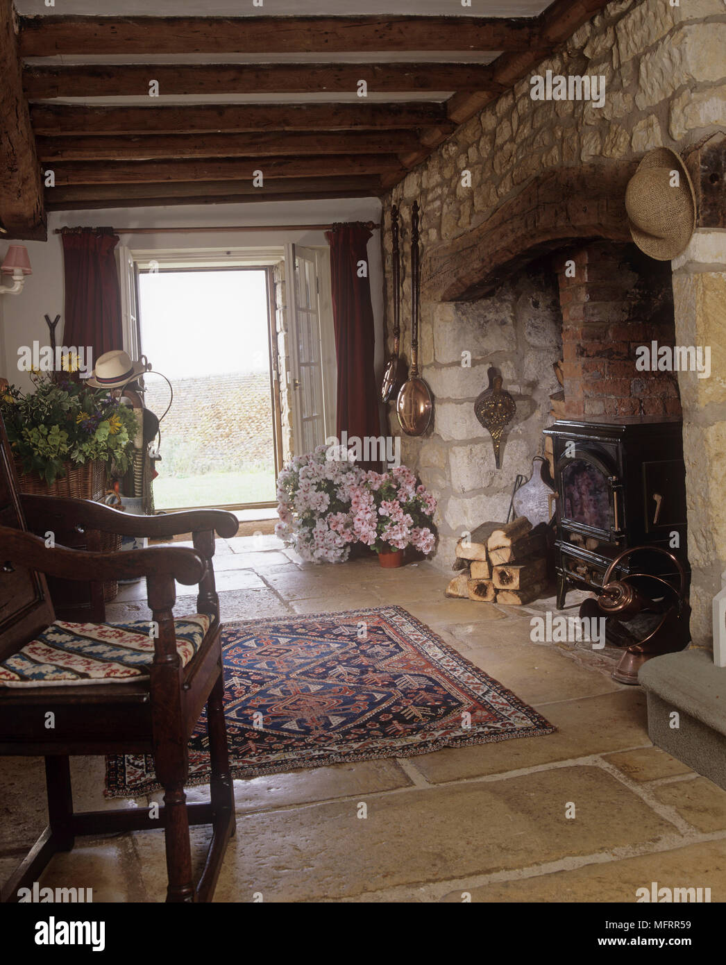 Landhausstil Flur mit Steinmauern, Kaminecke und Steinplatten Boden Stockfoto