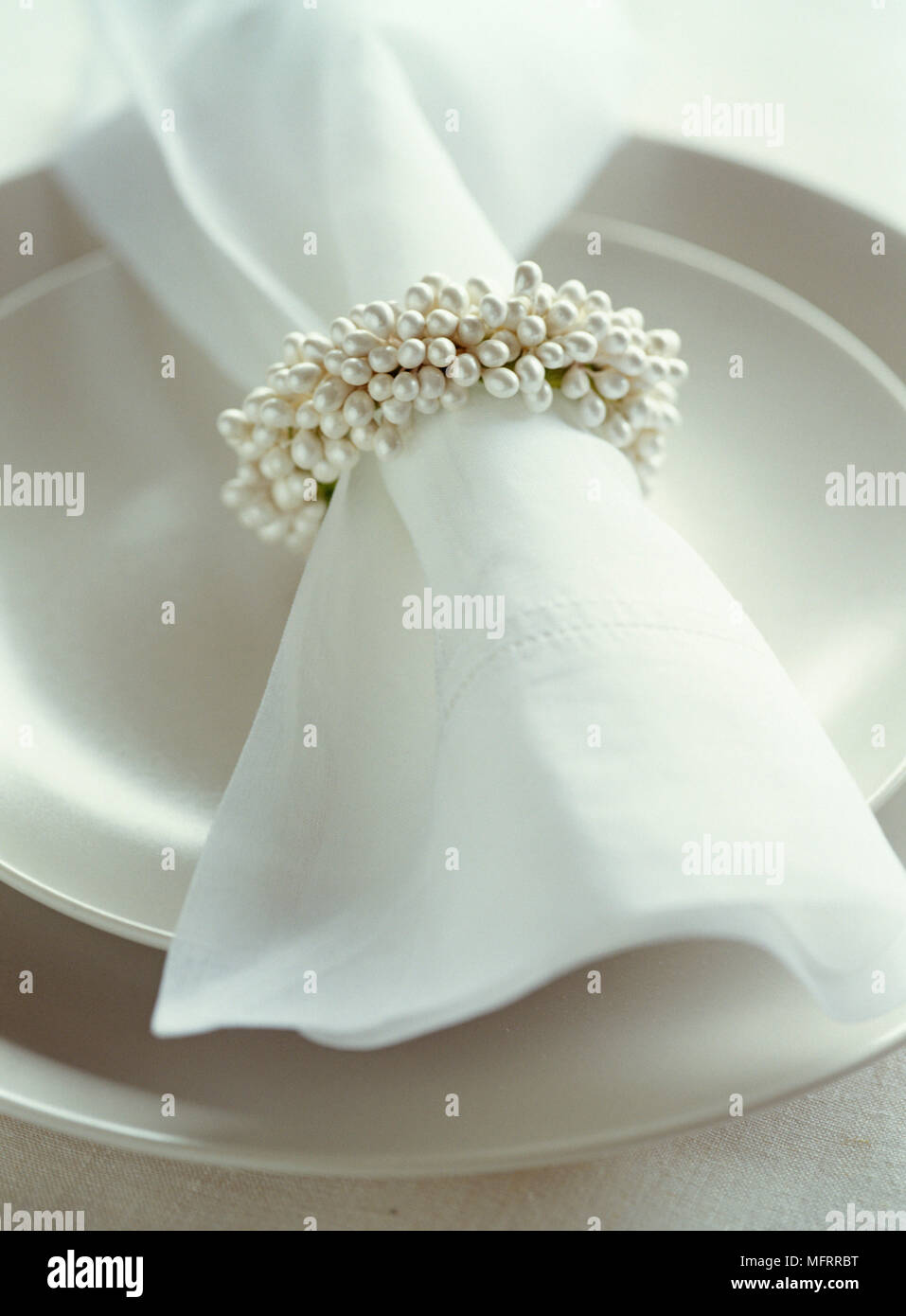 Weisse Serviette mit Perle stil Serviettenring auf neutrale Farbe Platten Stockfoto