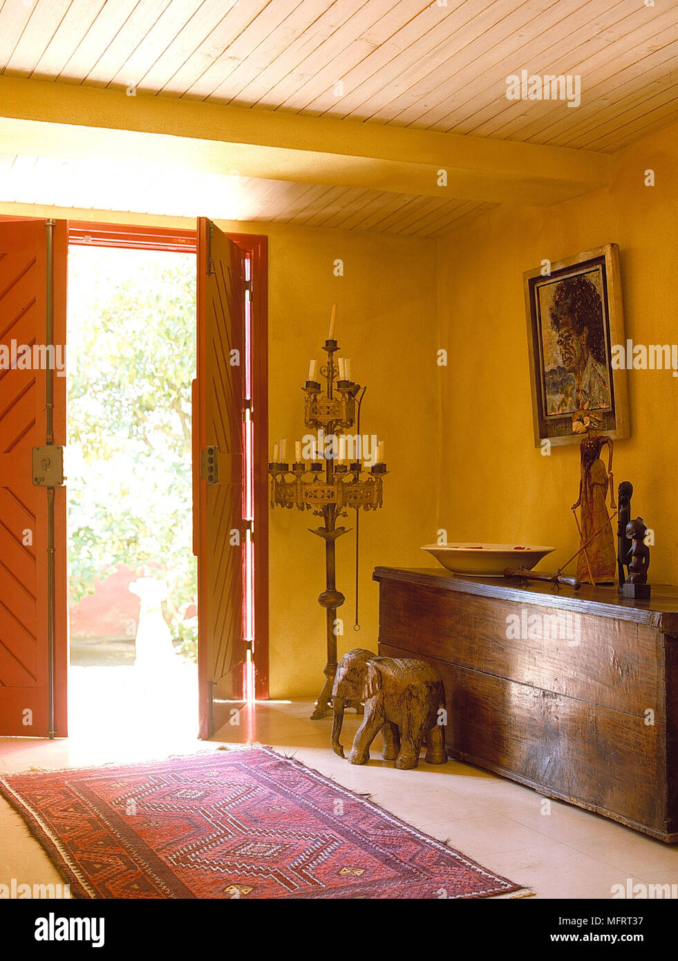 Doppelte vordere Türen öffnen in gelben Flur mit hölzernen Kasten Stockfoto