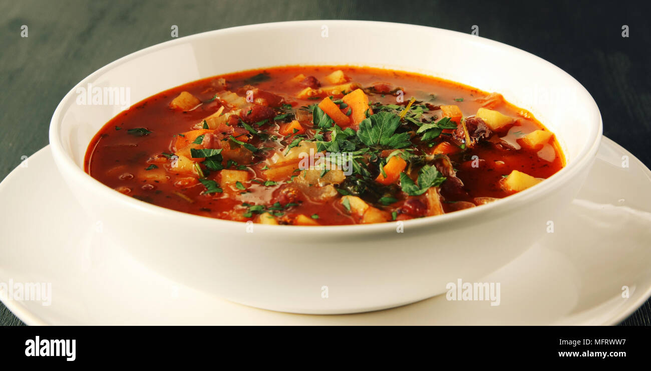 Tomatensuppe mit roten Bohnen, Kartoffeln und Karotten. Vegane Ernährung. Europäische Küche. Vegetarisches Gericht. Hauptgericht. Bio Mahlzeit. Von der Seite. Breite Foto. Stockfoto